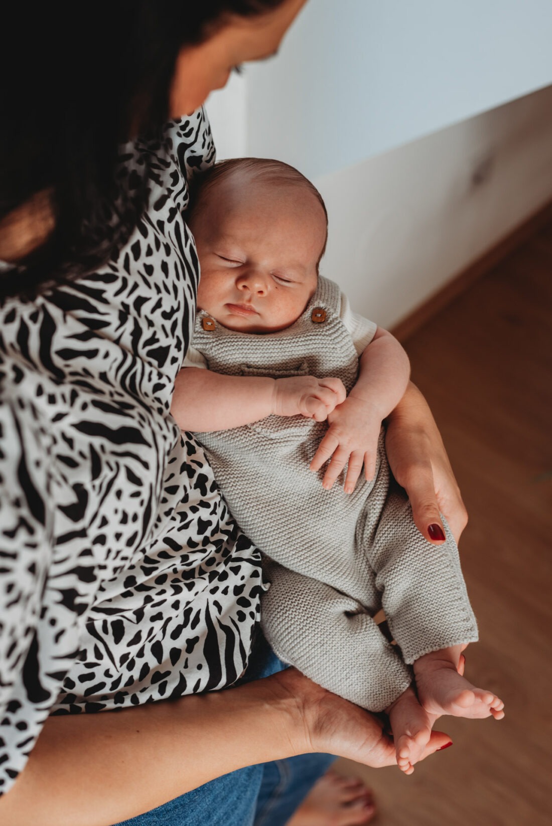 Newborn baby sleeping peacefully in mother’s arms.