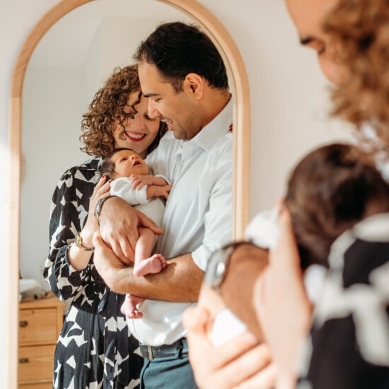 fresh parents looking at their newborn baby