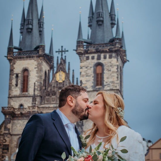 Newlyweds share a kiss with Prague’s iconic Gothic towers in the background, a perfect blend of romance and history.