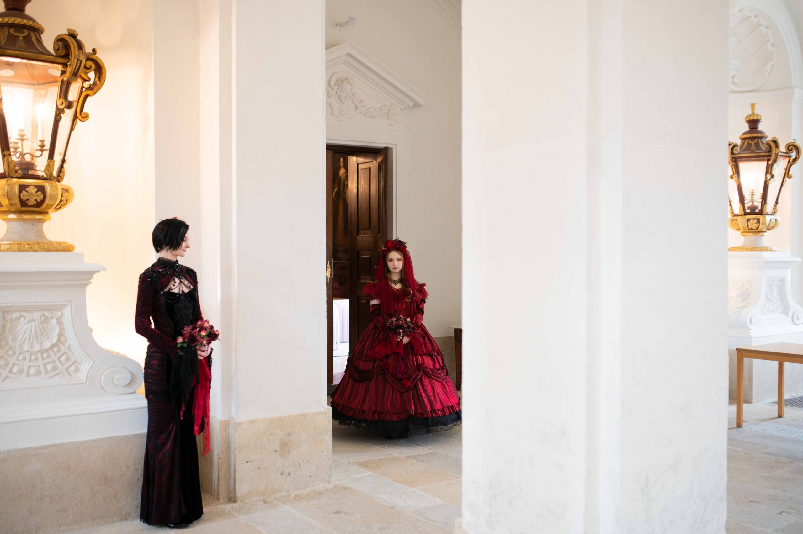 First look - a couple in baroque wedding attire standing in historic hall at Eckartsau Castle