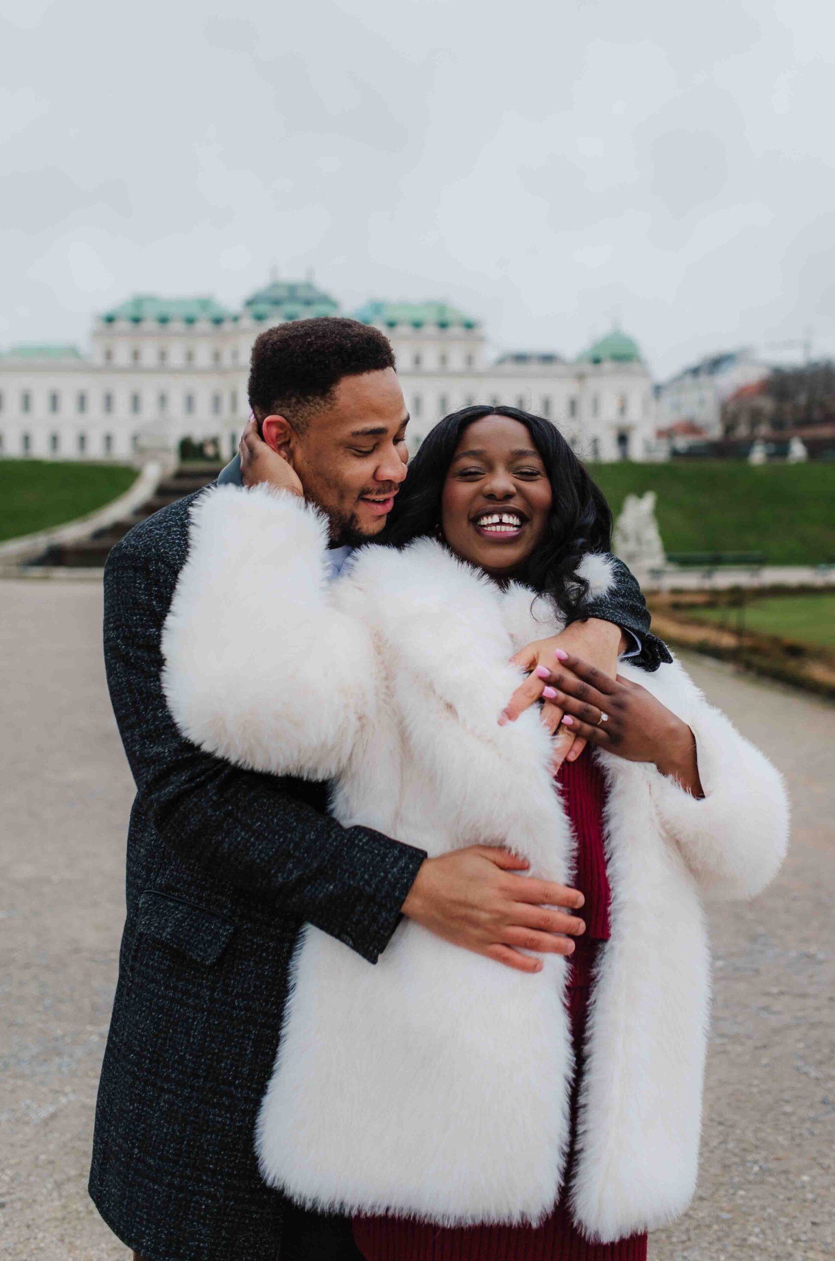 Engaged couple laughing together after a proposal at Belvedere in Vienna