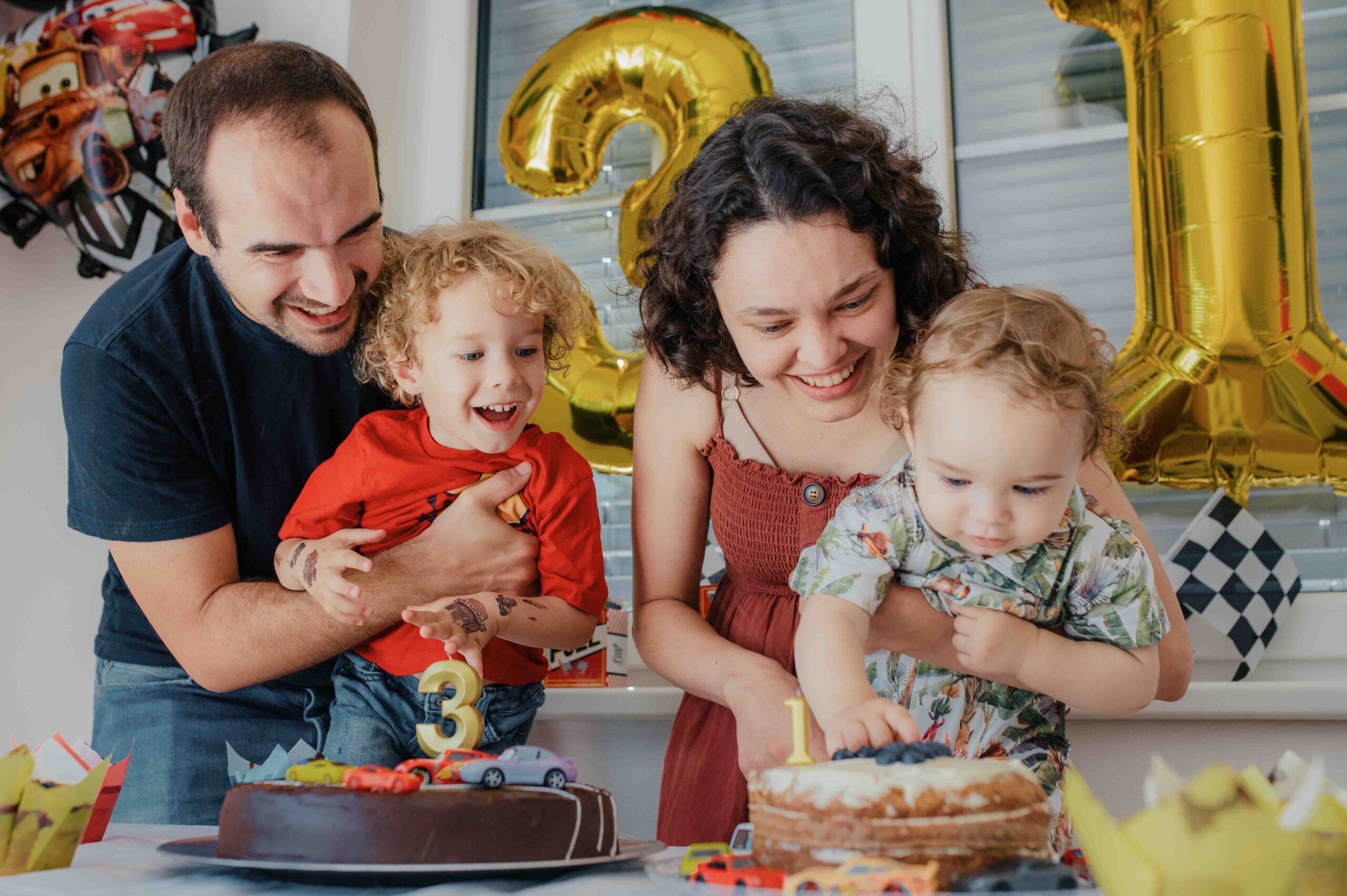 Family celebrating children birthday party with cake at their new home