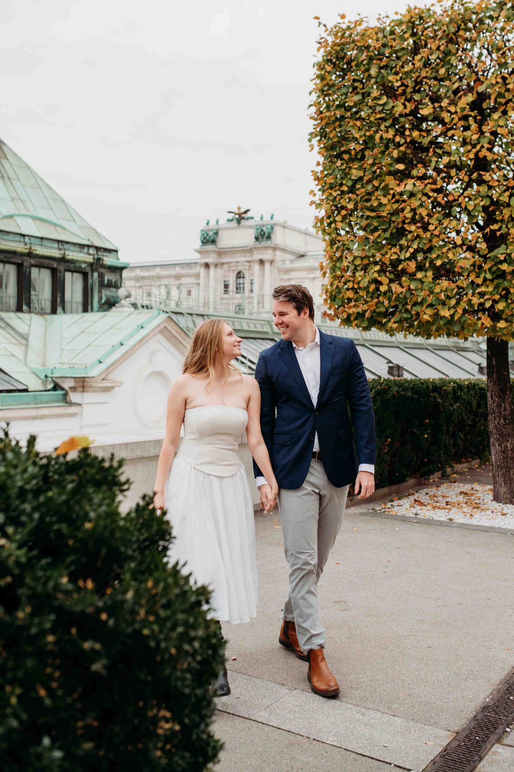 Couple walking hand in hand during photo shoot in Vienna city center