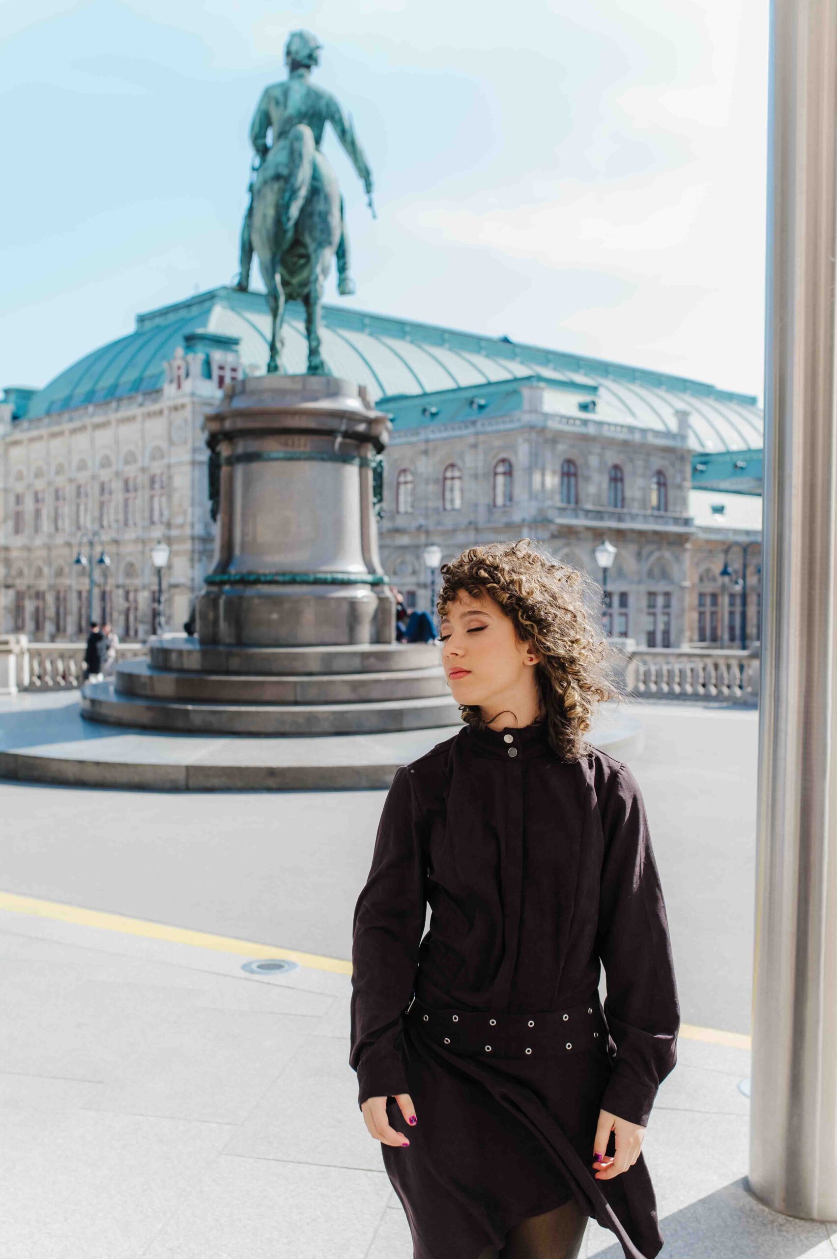 Teenage girl portrait near Vienna State Opera with horse statue in background