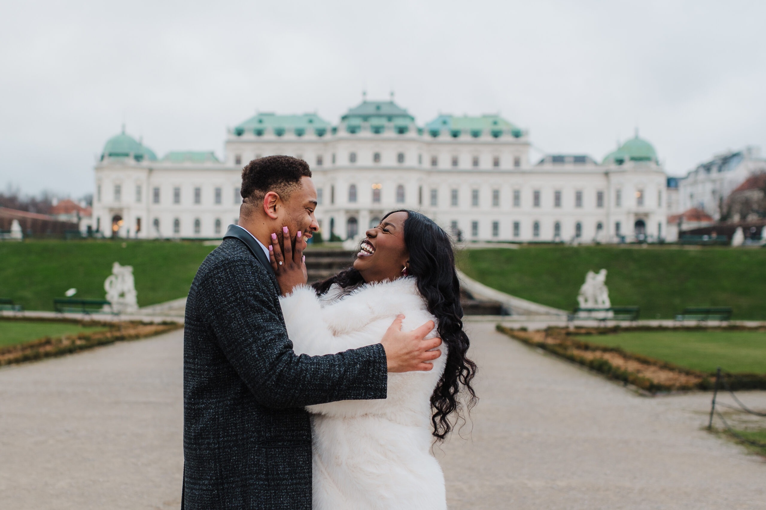Couple laughing together during a photo shoot at Belvedere Palace in Vienna.