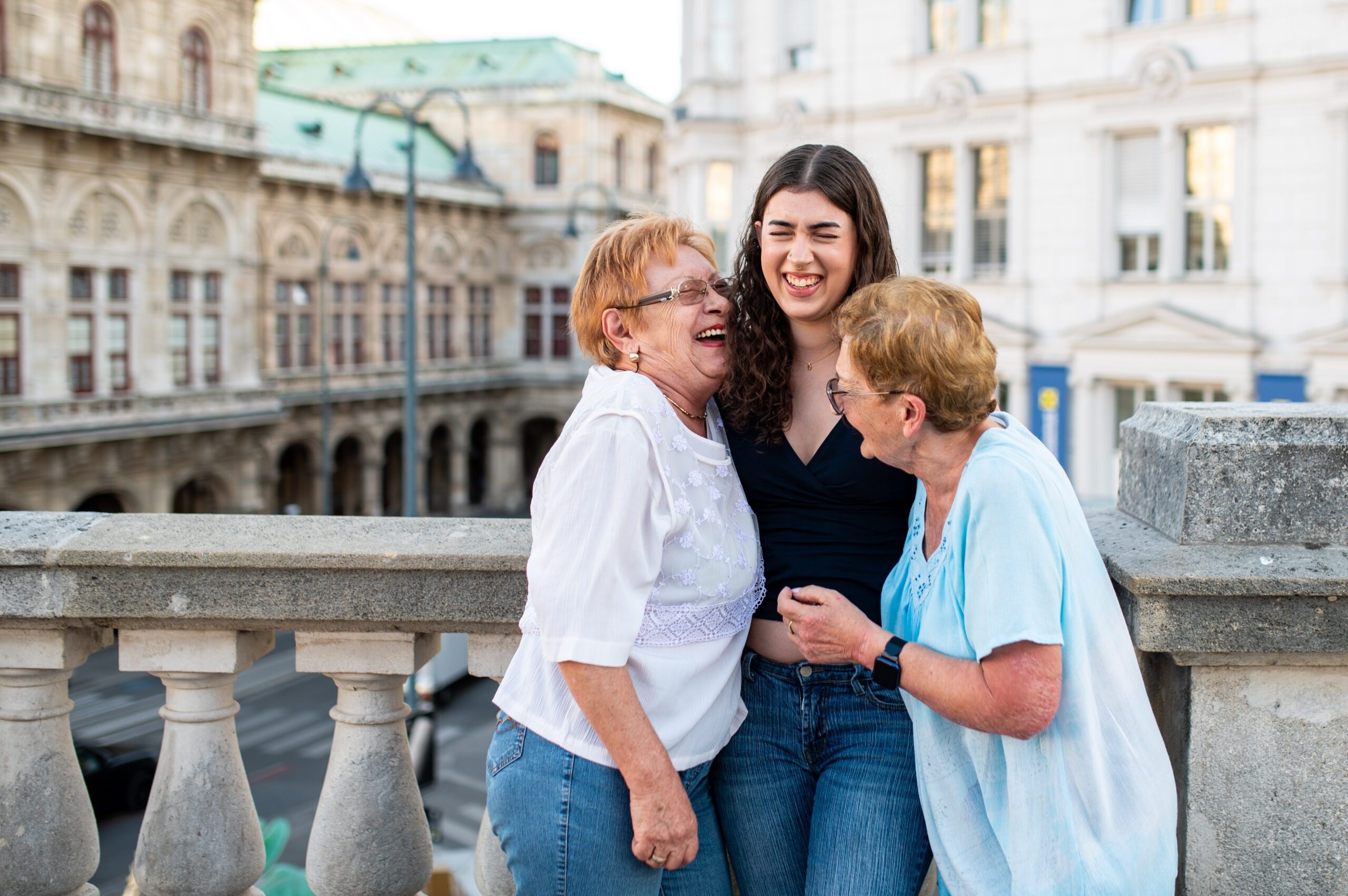 Three generations of women laughing together during a family photo shoot in central Vienna.